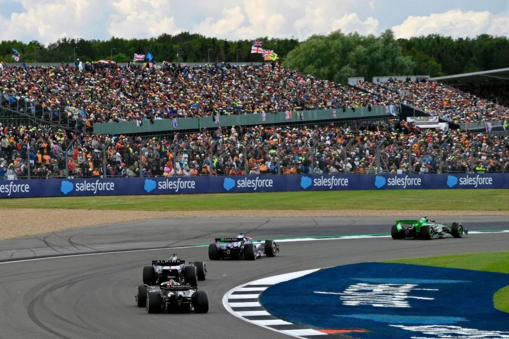 Formula 1 cars racing past spectators at Silverstone Circuit